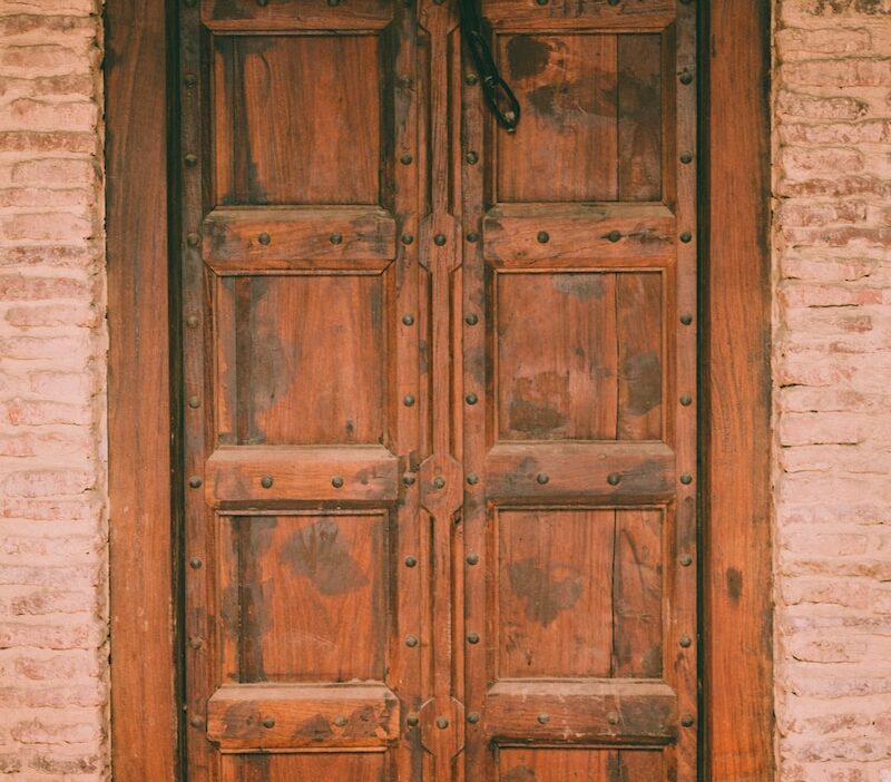 brown wooden door with padlock