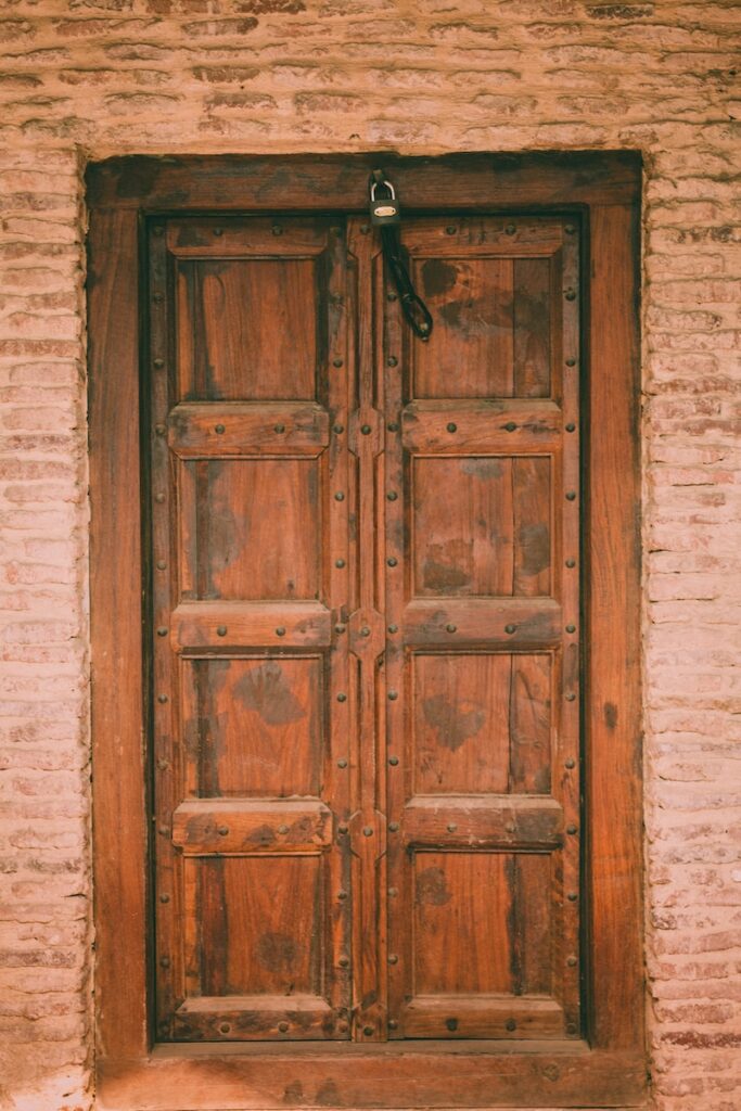 brown wooden door with padlock