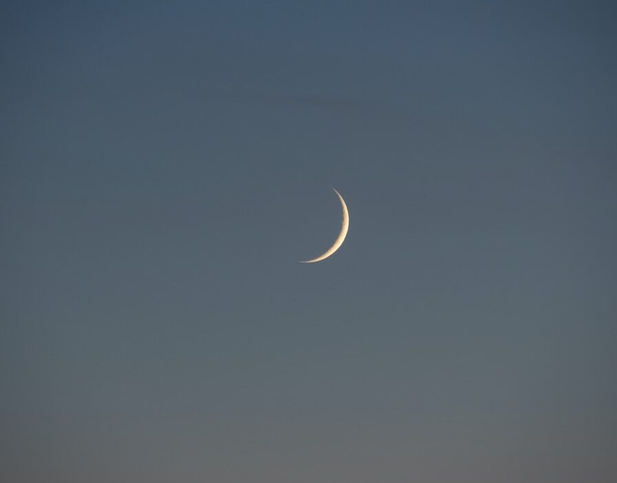 white crescent moon in the sky