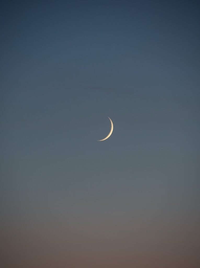 white crescent moon in the sky