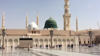 people walking outside a dome mosque building