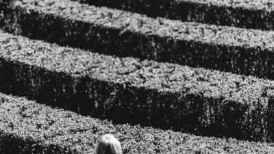 grayscale photo of person inside the plant formation