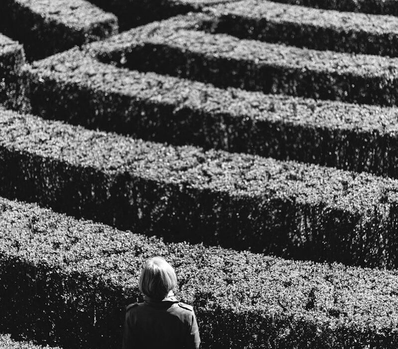 grayscale photo of person inside the plant formation