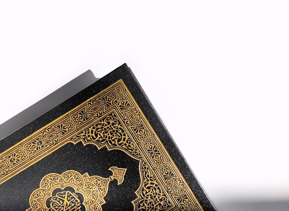 A beautifully detailed Quran cover with golden patterns on a white background, symbolizing spirituality.