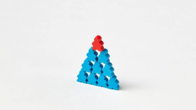 A stack of blue and red wooden blocks arranged in a triangle on a white background.